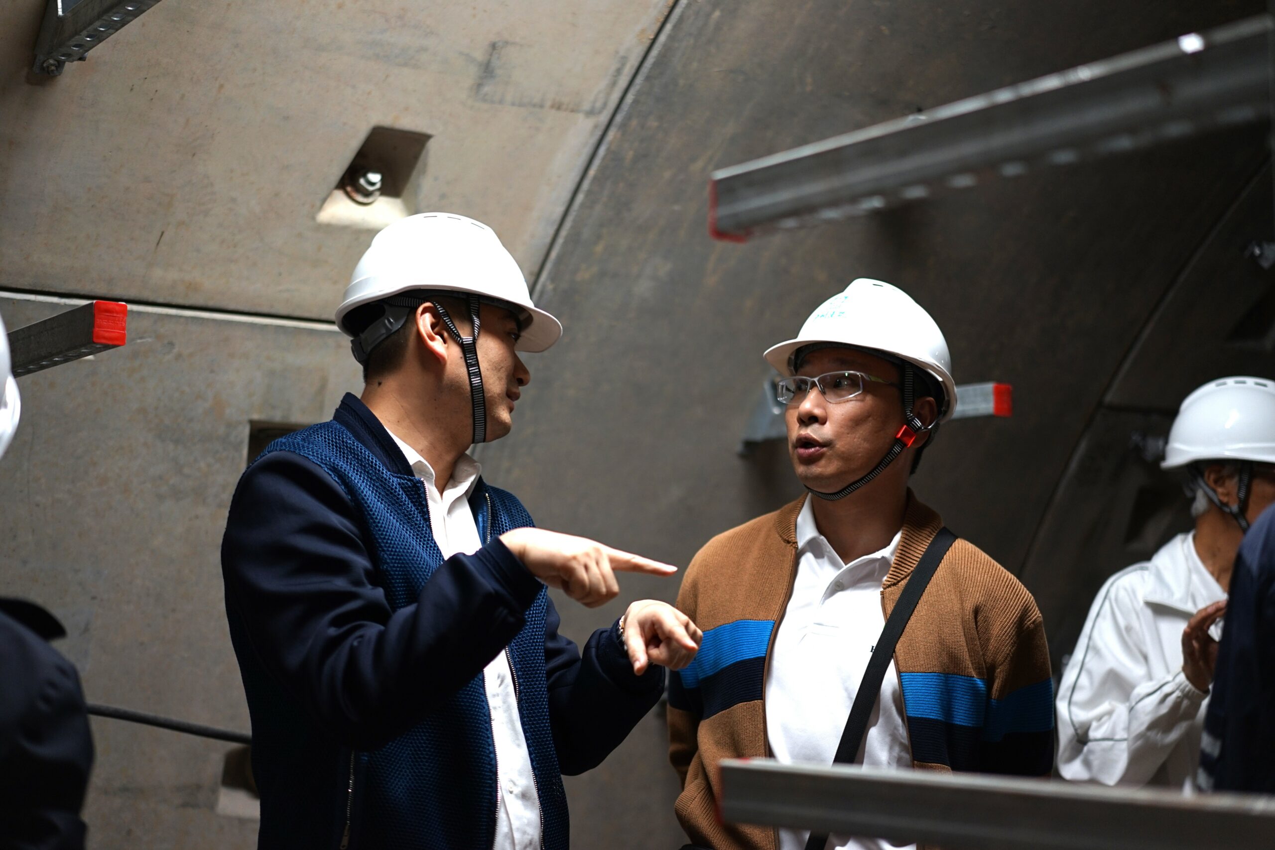 廣州市建築集團有限公司建築工業化辦公室副主任過勇先生(左)與會員王益強先生(右)於地下管道內就項目細節進行交流