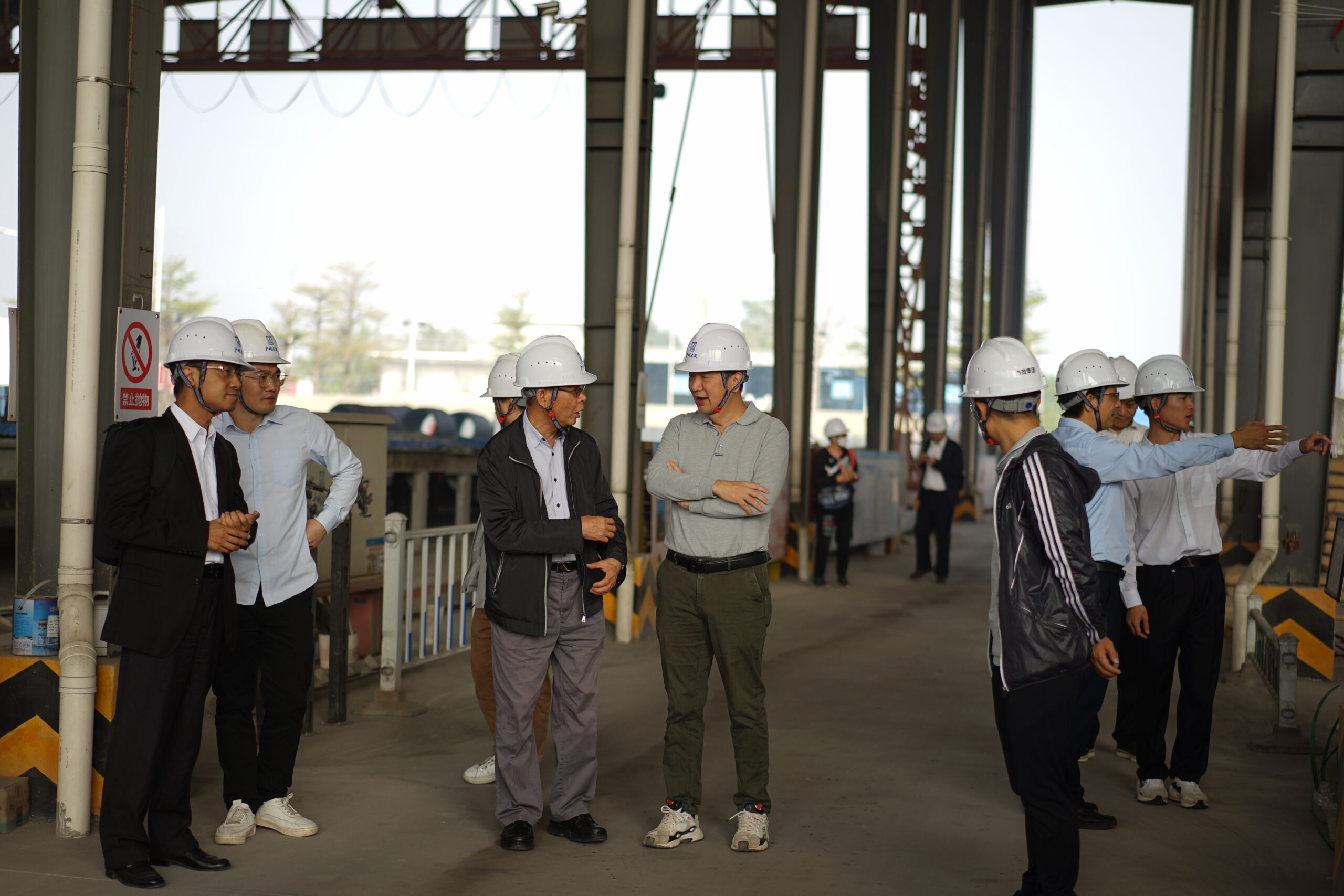廣州市政工程機械施工有限公司資深工程師李建明先生(灰色衫)向會長潘家強先生介紹路橋基地